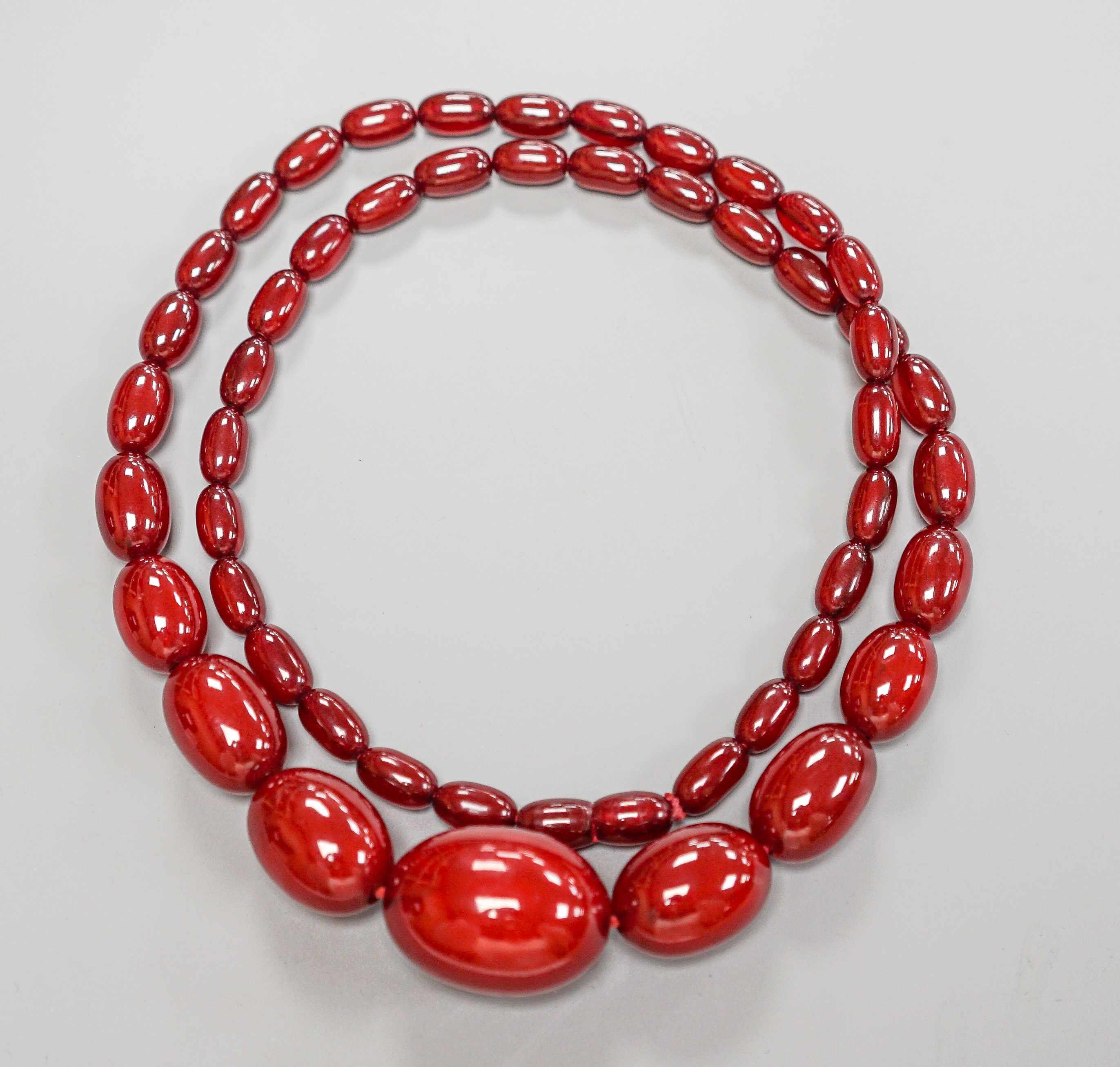 A single strand graduated simulated cherry amber bead necklece, 72cm, gross weight 63 grams.